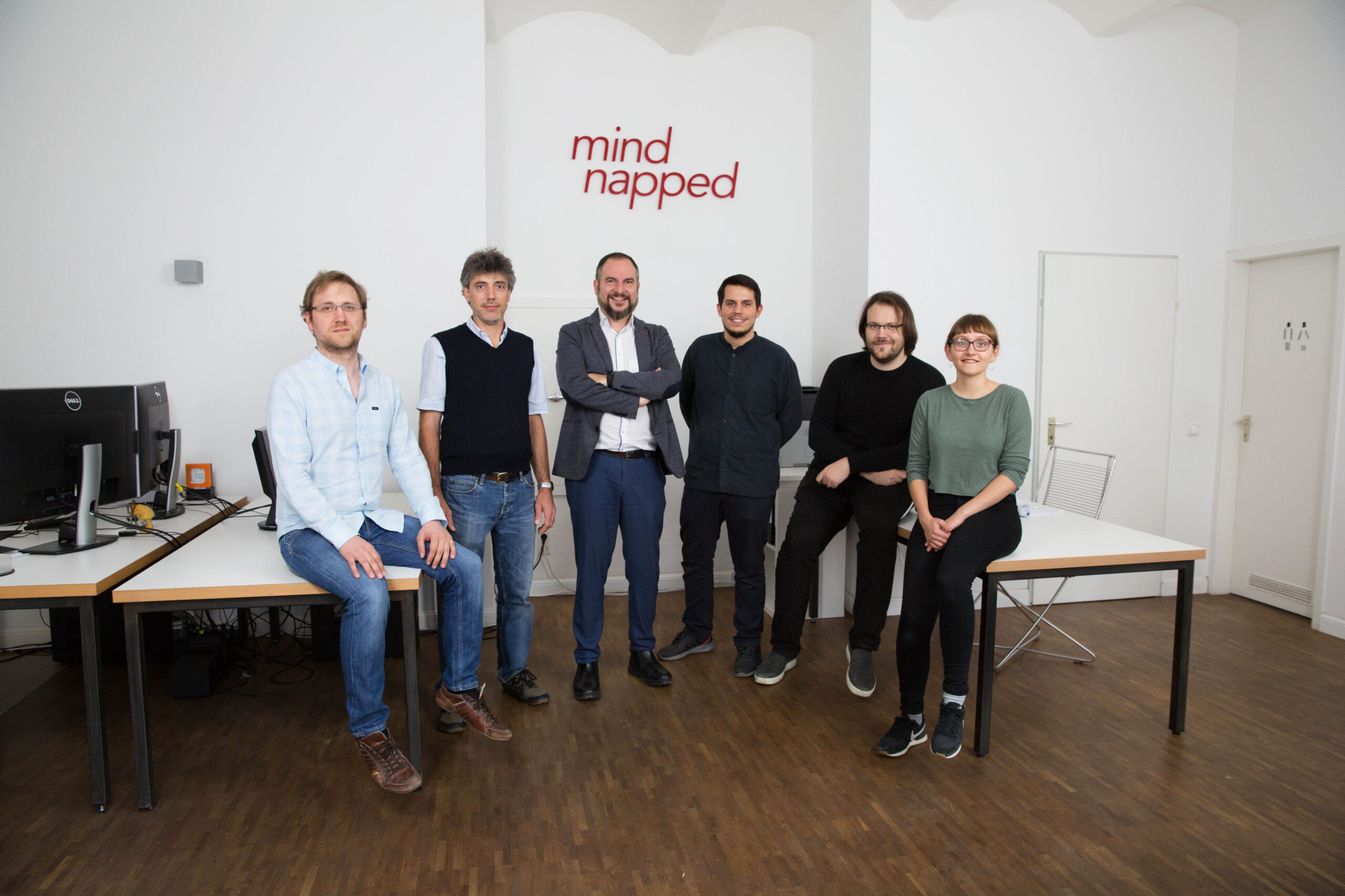 Das Team von mindnapped Filmproduktion steht vor dem Logo im neuen Studio